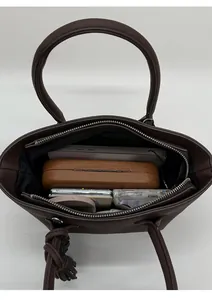 Top view of spacious interior of dark brown bucket bag showing daily essentials and zip pocket