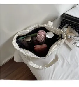 Detailed internal storage view of large white quilted tote bag with daily essentials