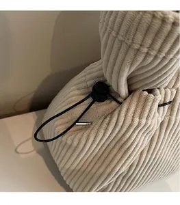 Detail of corduroy texture and black drawstring with spherical adjustment buckle