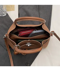 Vue intérieure du sac cabas en daim marron avec compartiments et fermoir métallique