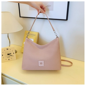 Dettaglio borsa shopper rosa con trama intrecciata, finitura pelle e decori interni