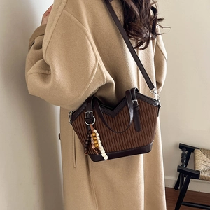 Detailansicht einer braunen Falten-Beuteltasche mit vintage Perlenquasten-Accessoire