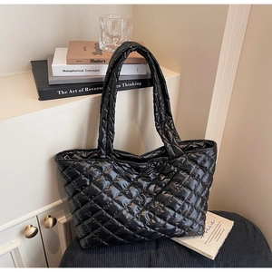 Detail view of black glossy quilted tote bag with spacious interior and soft padded straps