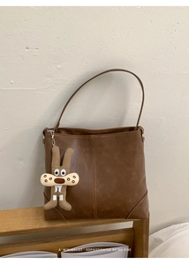 Brown vintage faux leather tote bag with vertical stitching and cute rabbit charm detail