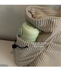 Close-up of the side storage pocket on this beige corduroy tote bag with a water bottle