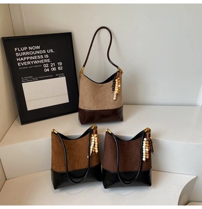 Detailed view of three vintage suede bucket bags in beige, brown and dark coffee colors