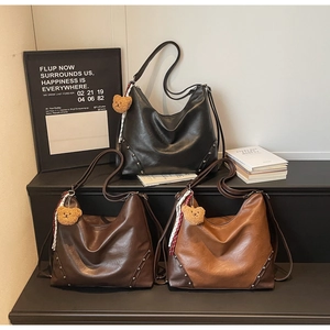 Detailed view of vintage tote bags with metal studs and plush bear charms in three colors