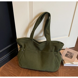 Close-up of olive green corduroy tote bag with wide strap and side drawstring detail