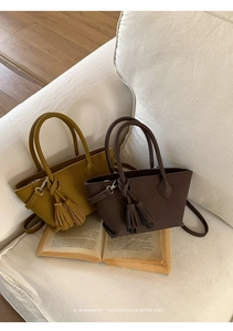 Close-up of mustard yellow and dark coffee retro satchel bags with stylish double tassels