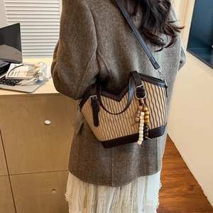 Detail der Vintage Beuteltasche mit Faltenstoff, braunem Lederbesatz und Perlenquaste