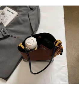 Detail view of large brown suede bucket bag interior showing spacious capacity with items