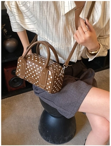 Lifestyle view of a vintage polka dot pillow bag worn as a stylish crossbody bag