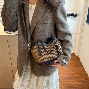Nahaufnahme der Retro-Beuteltasche mit Faltentextur und stilvoller Perlenquaste