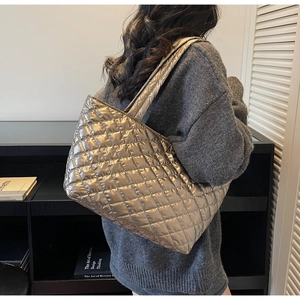 Close-up of quilted champagne gold tote bag showing luxury metallic texture and stitching