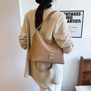 Dettaglio della borsa hobo marrone con trama a quadri in rilievo e particolari della tracolla