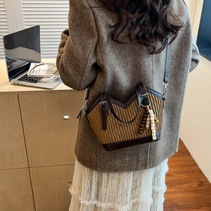 Detailansicht einer Retro-Beuteltasche mit Plissee-Struktur und Perlenanhänger