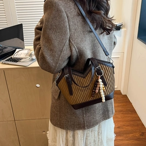 Detail der Vintage-Beuteltasche mit Faltenstruktur und Holzperlenanhängern am Modell