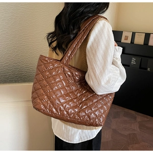 Detailed view of brown quilted tote bag with shiny waterproof fabric and large rhombus pattern