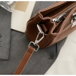 Close-up of premium silver hardware and leather texture on a brown shoulder bag