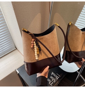 Détail du sac seau bicolore avec texture en daim et perles décoratives en bois