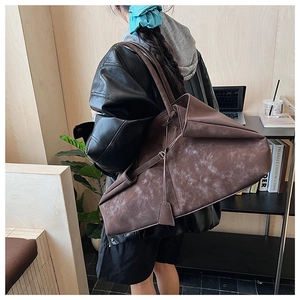 Brown vintage leather tote bag shown on shoulder with a spacious and slouchy silhouette