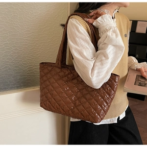 Detailed side view of a brown quilted tote bag with a soft silk-like nylon texture
