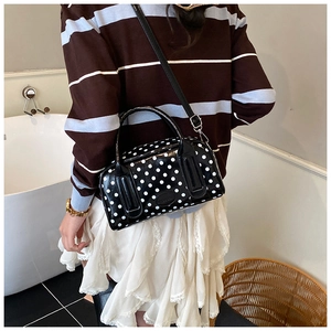 Polka dot Boston bag with double handles and adjustable strap shown on a model