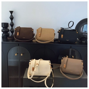 Detailed display of five small square handbags with polished gold twist-lock closures