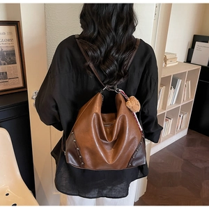 Close-up of retro brown patchwork leather shoulder bag with metallic stud details