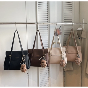 Quatre sacs cabas en cuir en noir, marron et beige avec des breloques ours en peluche