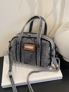 Retro washed denim boston bag with adjustable shoulder strap on minimalist background