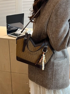 Vintage-Beuteltasche aus braunem Leder und Plissee-Stoff, getragen von einem Modell