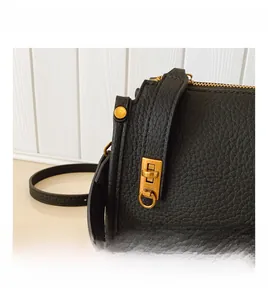 Details der schwarzen Handtasche aus Narbenleder mit goldenen Metallbeschlägen