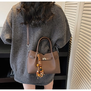Vue arrière d'un mannequin portant le sac à bandoulière marron rétro avec breloque perle