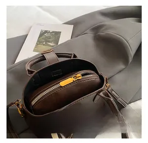 Detailansicht der dunkelbraunen Tasche mit goldener Hardware und Reißverschlussfach