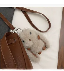 Detail of soft plush rabbit charm and silver hardware on a leather Kelly bag