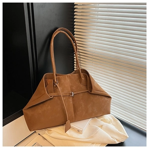 Macro shot of brown faux leather texture and unique wing-shaped fold on a tote bag