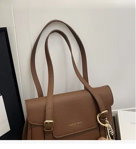 Détail du sac cabas marron grainé avec boucle dorée et pendentif décoratif