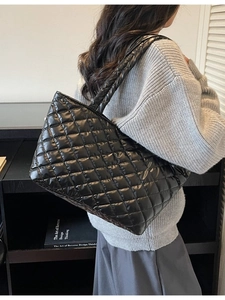 Large black quilted tote bag with diamond pattern shown on shoulder for daily commute