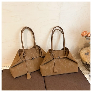 Detail of vintage suede tote bag with textured folds and long shoulder strap