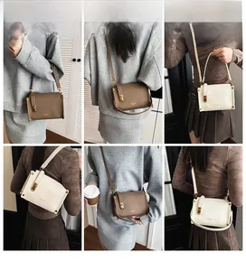 Detail view of stylish square crossbody bag with lychee grain leather and gold buckle