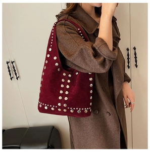 Dettaglio borsa hobo in pelle scamosciata bordeaux con borchie metalliche argento