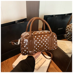Polished brown Boston bag with white polka dots featuring sturdy dual top handles