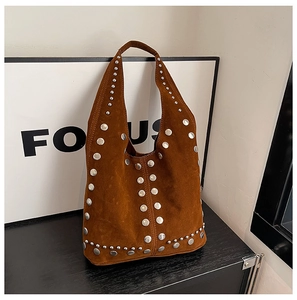 Dettaglio macro della borsa tote in pelle scamosciata marrone con rivetti in metallo argento