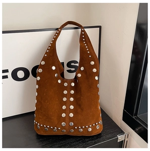 Dettaglio della borsa hobo in camoscio marrone con borchie metalliche e manico integrato