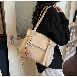 Détail du sac cabas beige en cuir grainé avec un pendentif ours en peluche sur l'anse