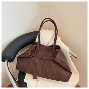Close-up of vintage brown tote bag texture and metal buckle detail on white corduroy