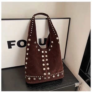 Dettaglio borsa hobo in pelle scamosciata marrone con borchie metalliche sui bordi