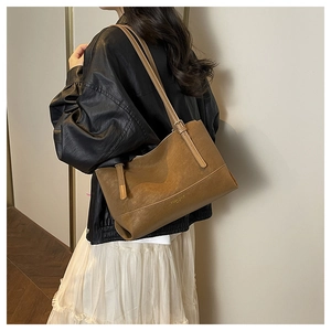 Detail of Florence brand logo and smooth caramel leather texture on the large tote bag