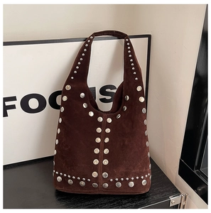 Dettaglio della borsa tote in pelle scamosciata marrone scuro con rivetti argentati densi